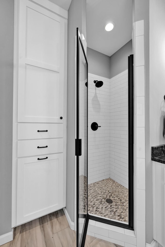 bathroom with a tile shower and hardwood / wood-style flooring