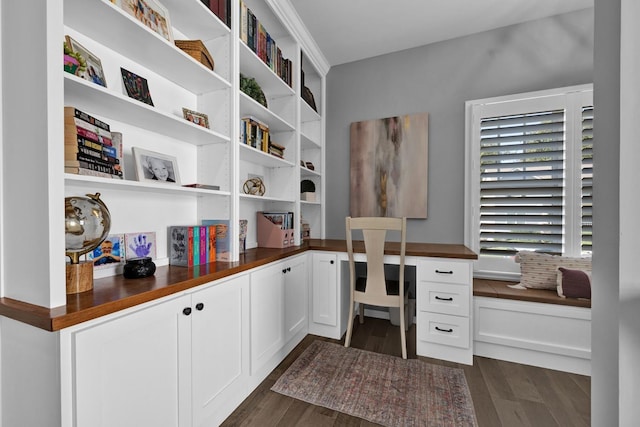 office space with dark hardwood / wood-style floors and built in desk