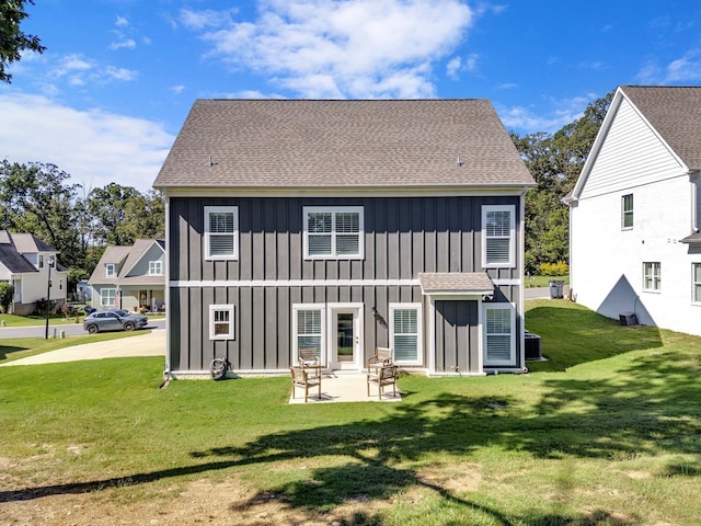 back of house with a patio and a lawn