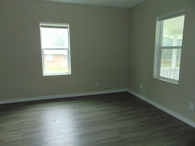 unfurnished room with dark wood-type flooring