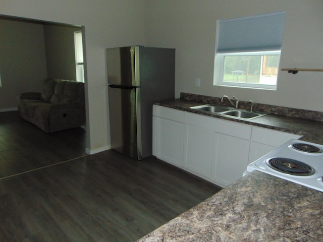 kitchen with white cabinets, dark hardwood / wood-style floors, sink, and stainless steel refrigerator