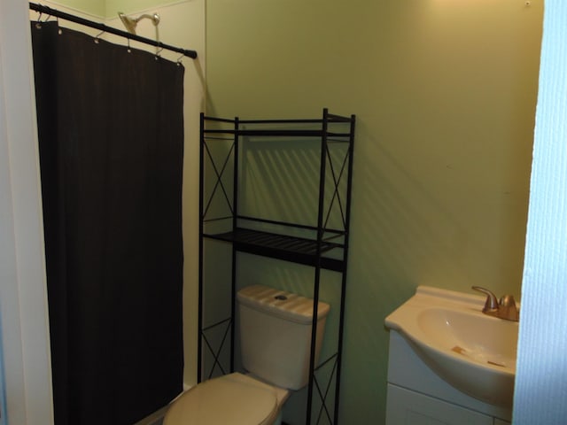 bathroom featuring vanity, curtained shower, and toilet