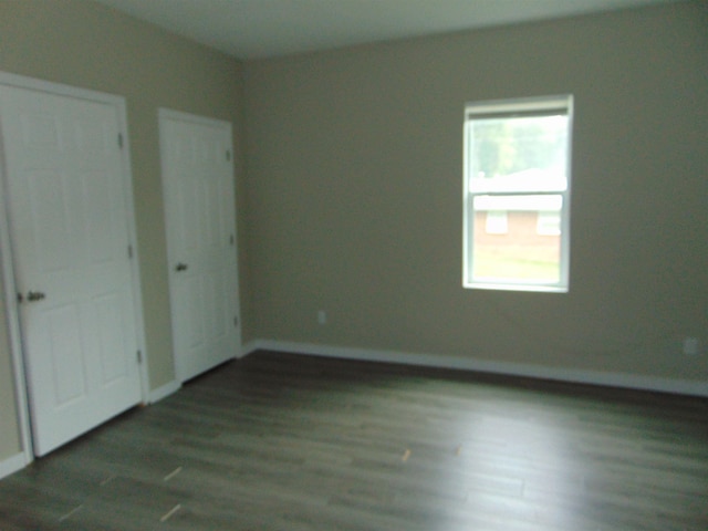 spare room with dark hardwood / wood-style floors