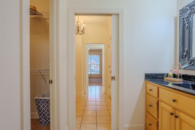 bathroom featuring tile patterned flooring, vanity, and ornamental molding