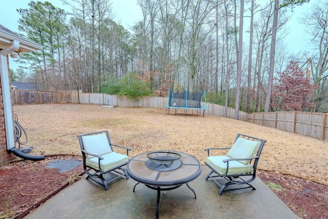 view of patio with a fire pit and a trampoline