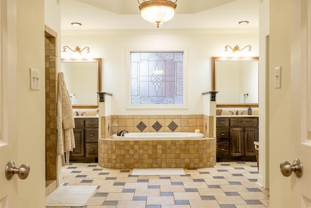 bathroom with tiled bath, crown molding, and vanity