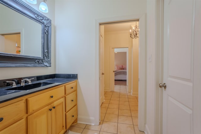 bathroom featuring tile patterned floors, vanity, ornamental molding, and a chandelier