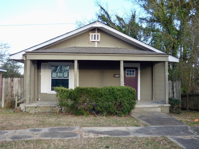 bungalow-style home featuring a porch and fence