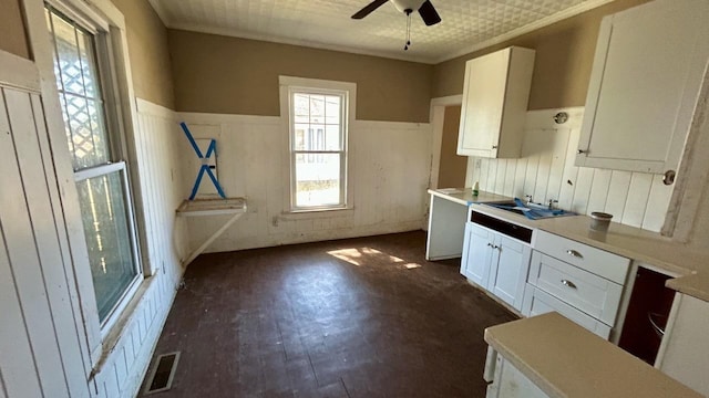 kitchen with visible vents, a wainscoted wall, dark wood-style floors, white cabinetry, and ceiling fan