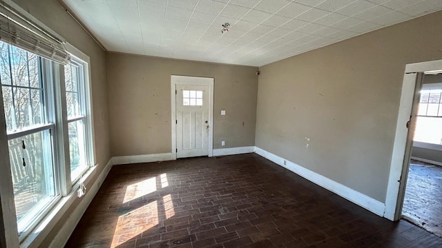 interior space featuring brick floor and baseboards