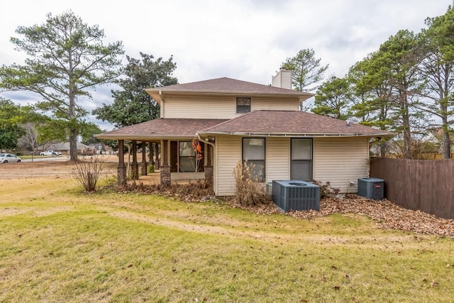 rear view of house with covered porch, a yard, and central air condition unit