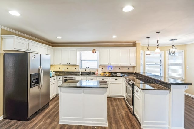 kitchen with white cabinets, crown molding, dark hardwood / wood-style floors, appliances with stainless steel finishes, and a kitchen island