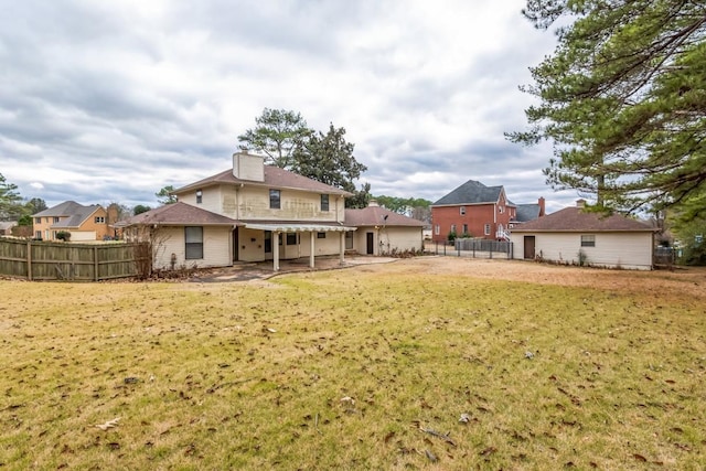 back of property with a patio area and a yard