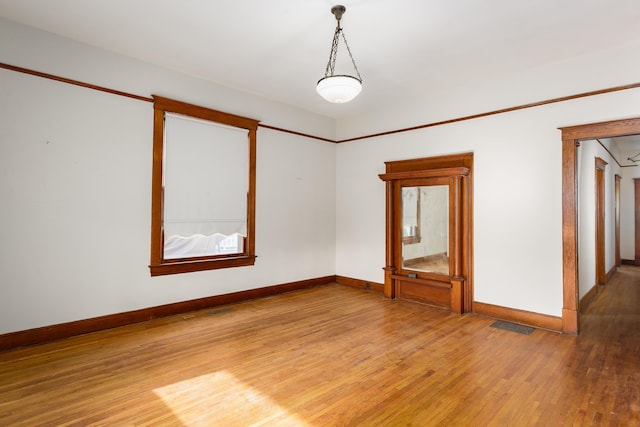 unfurnished room featuring light wood-style flooring, baseboards, and visible vents