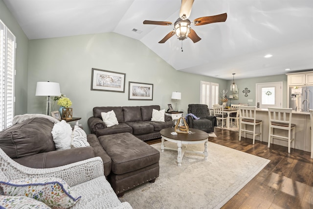 living room with lofted ceiling, ceiling fan, dark wood-type flooring, and visible vents