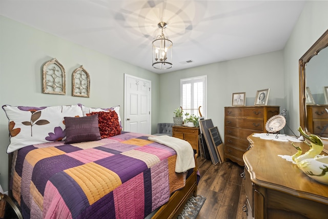 bedroom with a chandelier, dark wood-style flooring, and visible vents