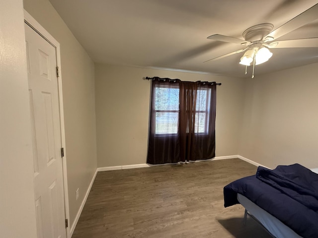 bedroom featuring wood finished floors, baseboards, and ceiling fan
