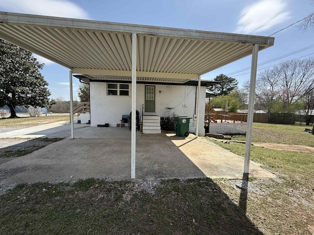 view of patio / terrace with entry steps, a carport, and fence