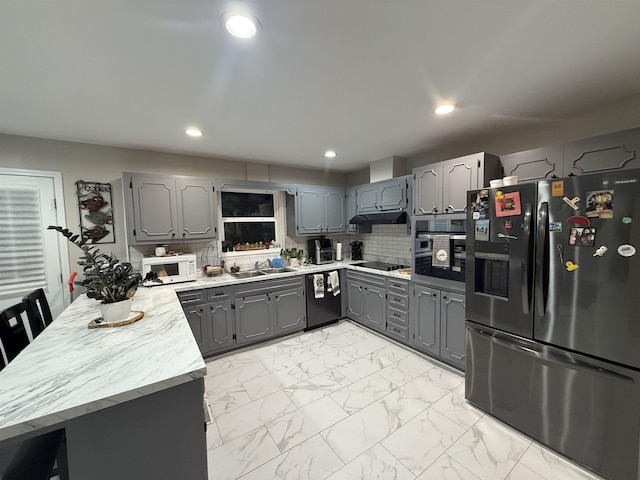 kitchen with a sink, black appliances, gray cabinets, marble finish floor, and a peninsula