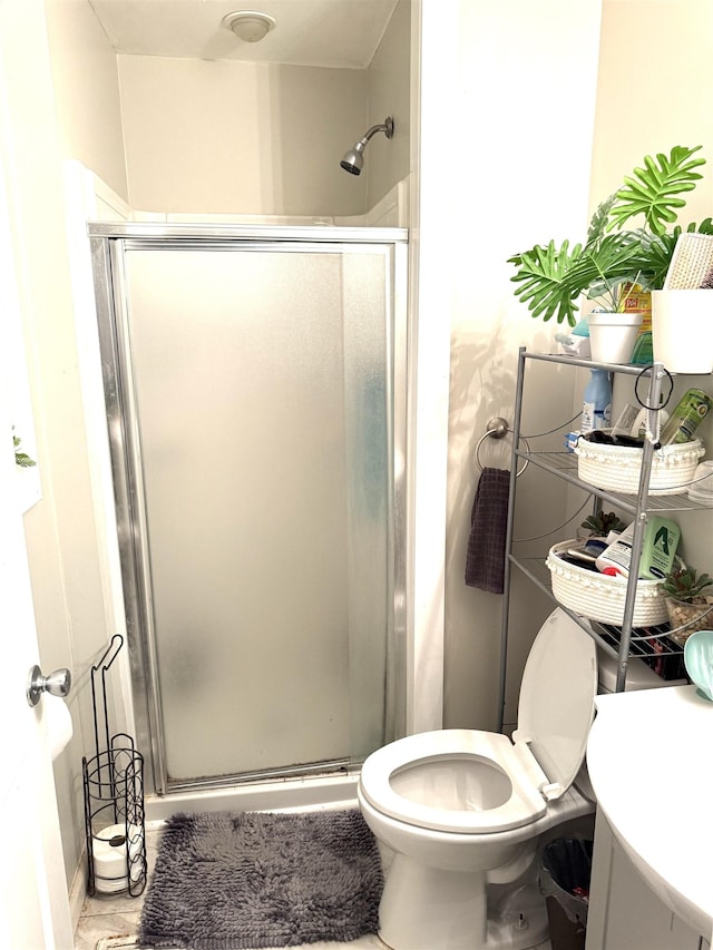 bathroom featuring a shower with shower door and toilet