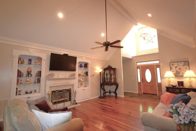 living area with high vaulted ceiling, a fireplace with flush hearth, beamed ceiling, ceiling fan, and wood finished floors
