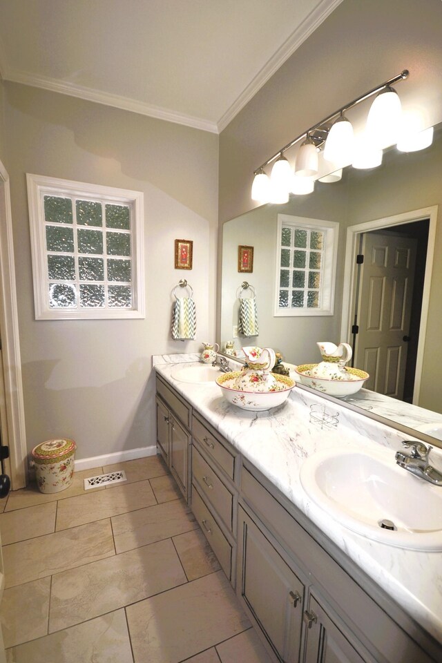 full bathroom featuring baseboards, double vanity, a sink, and crown molding