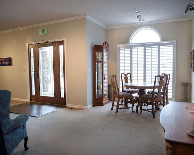 carpeted foyer entrance with a textured ceiling and ornamental molding