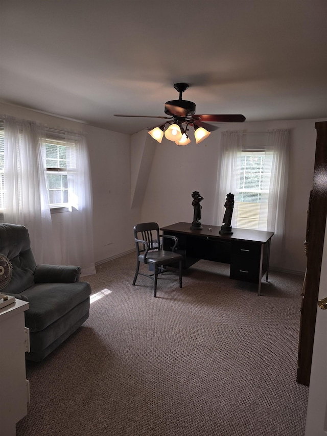 office space featuring a healthy amount of sunlight, ceiling fan, and dark carpet