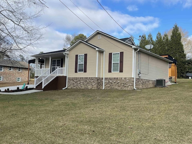 view of home's exterior with a lawn, central AC, and covered porch