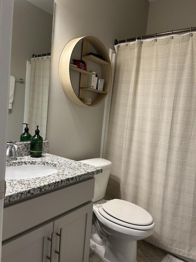  - bathroom with vanity, toilet, and tile patterned floors
