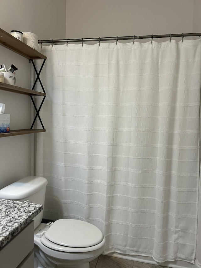  - bathroom featuring toilet, vanity, and a shower with curtain