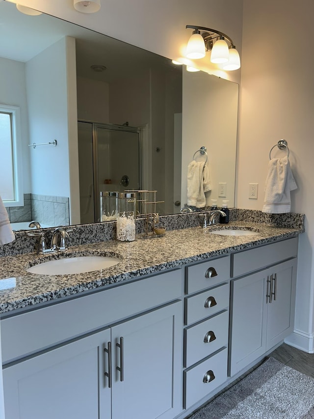 - bathroom featuring a shower stall and double vanity