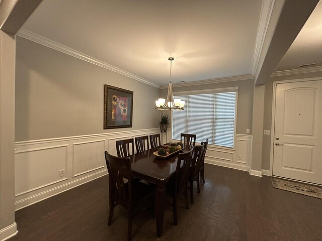  - dining area with dark wood-style flooring, a chandelier, crown molding, a decorative wall, and wainscoting