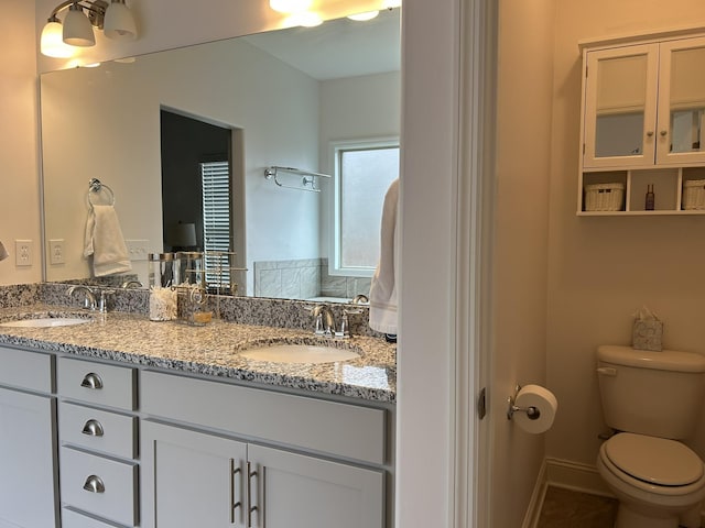  - full bath featuring toilet, double vanity, and tile patterned floors