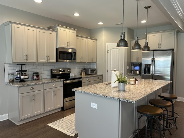  - kitchen with stainless steel appliances, dark wood-style flooring, a center island with sink, decorative backsplash, and recessed lighting
