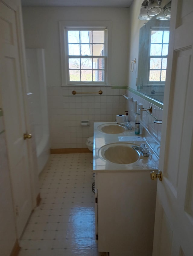 full bathroom featuring plenty of natural light, toilet, and a sink