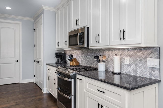 kitchen featuring dark wood-type flooring, tasteful backsplash, appliances with stainless steel finishes, and white cabinets