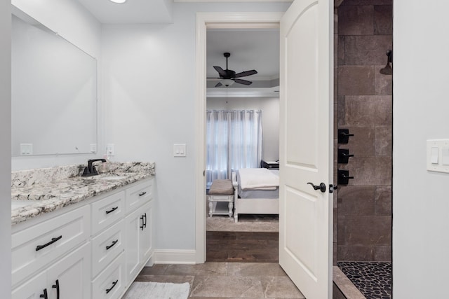 ensuite bathroom with a tile shower, baseboards, a ceiling fan, vanity, and connected bathroom