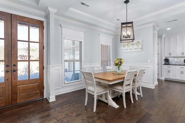 dining space with a wainscoted wall, french doors, dark wood-type flooring, and visible vents