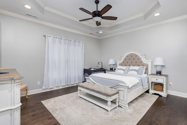 bedroom with hardwood / wood-style floors, baseboards, visible vents, and a tray ceiling