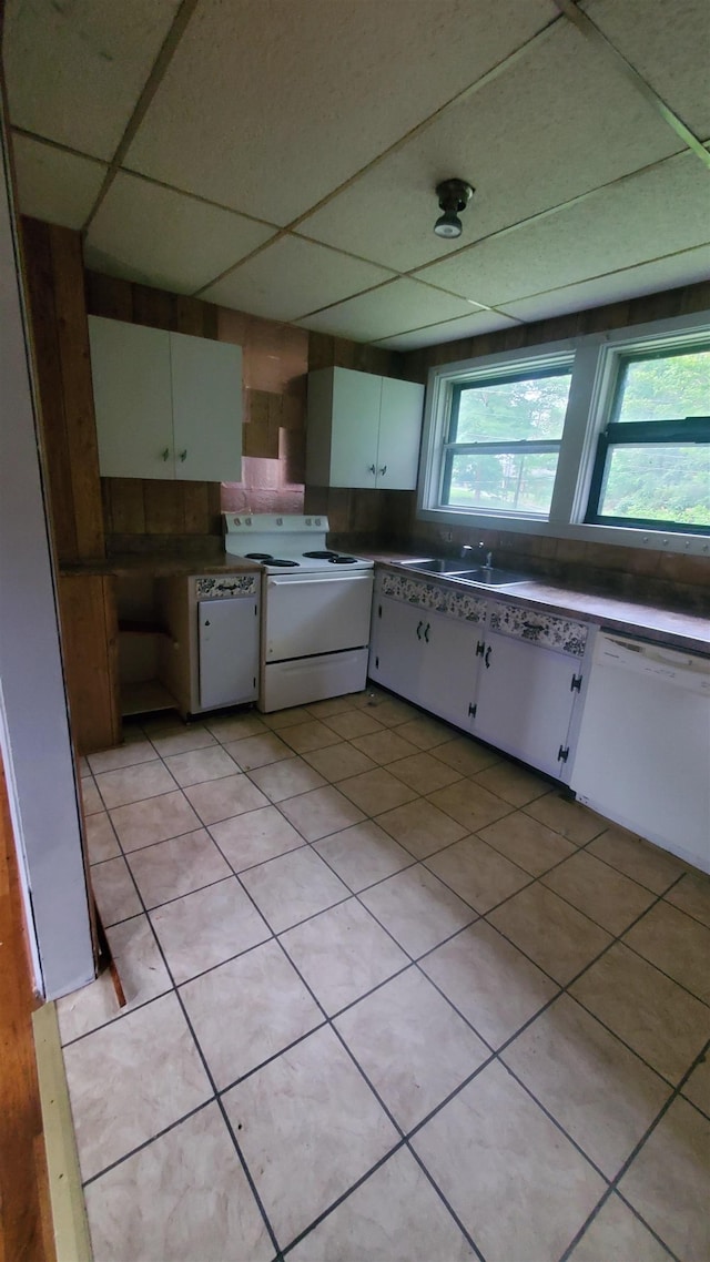 kitchen featuring sink, white appliances, light tile patterned floors, white cabinetry, and a drop ceiling