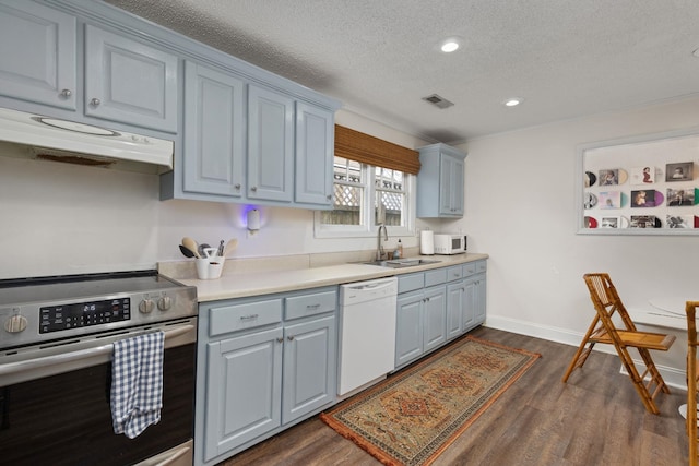 kitchen with a textured ceiling, dark hardwood / wood-style flooring, sink, and white appliances