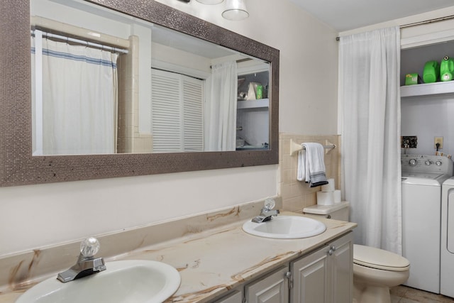 bathroom featuring toilet, vanity, and washer / dryer