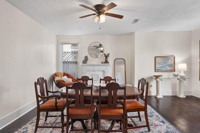 dining space with ceiling fan, dark hardwood / wood-style floors, and a textured ceiling