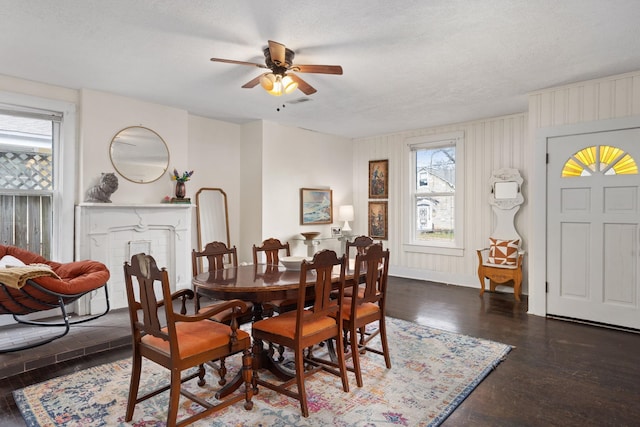 dining room with ceiling fan, dark wood-type flooring, and a textured ceiling