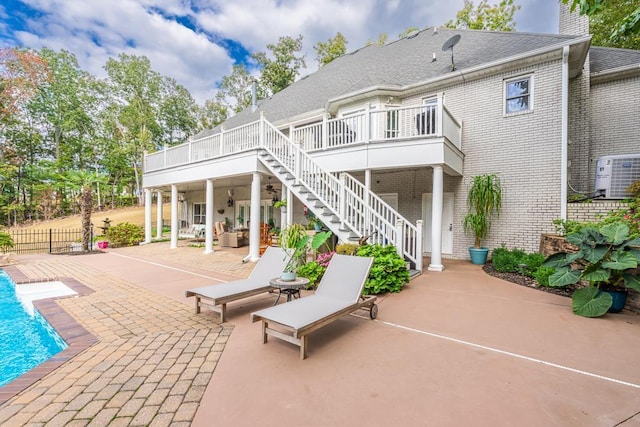  - rear view of house with a patio area, central air condition unit, stairway, brick siding, and fence