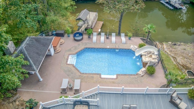  - view of pool with a water slide, a water view, and a patio