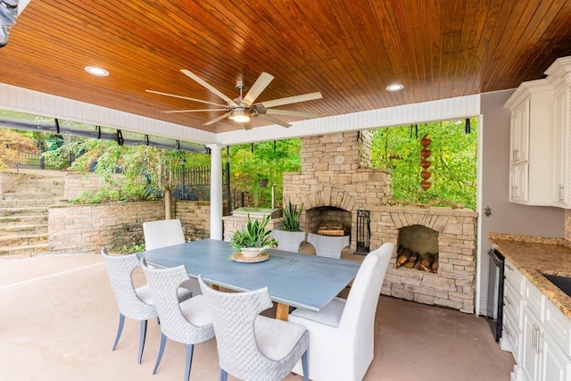  - view of patio / terrace featuring an outdoor stone fireplace, ceiling fan, and outdoor dining area