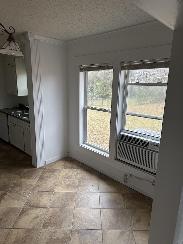 unfurnished dining area with sink, cooling unit, a textured ceiling, and ornamental molding