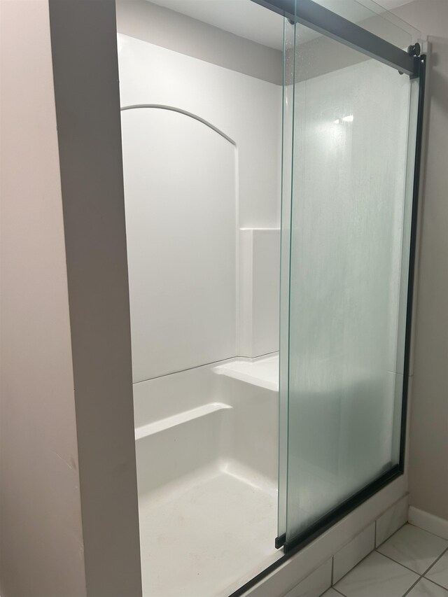 bathroom with tile patterned flooring and a shower with shower door